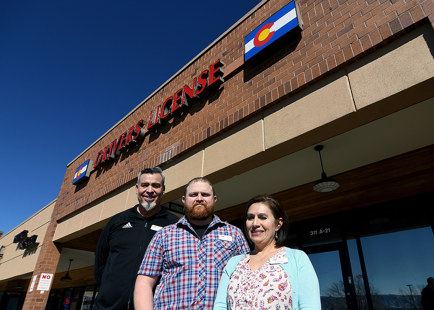 Three DMV Team Members in front of a driver license office